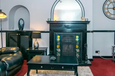 a living room with a fireplace and a couch at Cosy & Central 2BD Apartment Milngavie, Glasgow in Milngavie