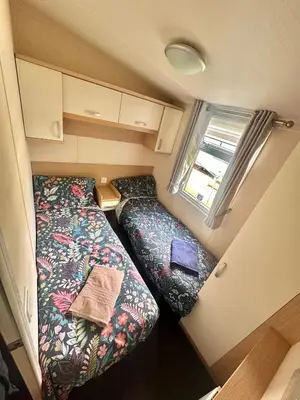 a small caravan with a bed and a window at Swift Moselle 2 Bedroom Caravan Located in Uddingston, Glasgow at Maryville Caravan Site in Uddingston