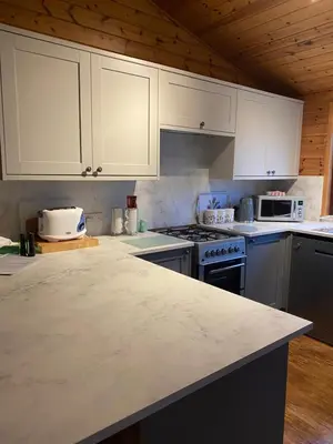 a kitchen with white cabinets and a counter top at Cozy Loch Lomond Lodge 27, Rowardennan in Rowardennan