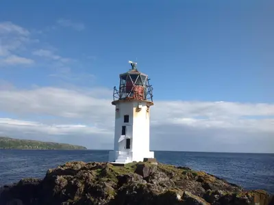 a white lighthouse on a rock in the ocean at Chapelhill Hideaway Isle of Bute licence AR00654F in Rothesay