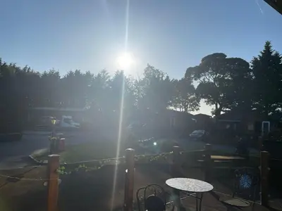 a sun rising over a parking lot with a table at Silver Birch Lodge in Auchterarder