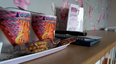 a table with two bags of popcorn and some snacks at Knight's Rest Guest House in Airdrie