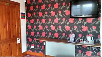 a kitchen with a black and red floral wallpaper at Knight's Rest Guest House in Airdrie