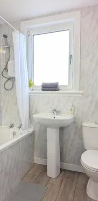 a bathroom with a sink and a toilet and a window at Campbeltown Loch in Campbeltown