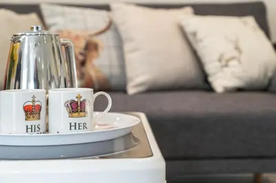 two coffee mugs sitting on a table next to a couch at Westmains Lodge in Callander