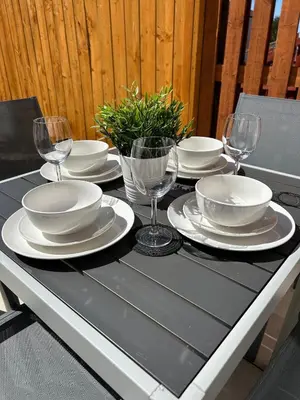 a table with white plates and wine glasses on it at 3 bedroom - 2 bathroom Townhouse in Corstorphine Near Murrayfield Stadium - Direct Bus To Edinburgh City Centre in 20 Minutes - Two Private Parking Spaces - Private Sunny Garden - Recently Refurbished in Edinburgh