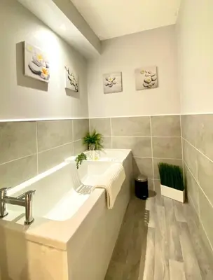 a white bathroom with a sink and a tub at 3 bedroom - 2 bathroom Townhouse in Corstorphine Near Murrayfield Stadium - Direct Bus To Edinburgh City Centre in 20 Minutes - Two Private Parking Spaces - Private Sunny Garden - Recently Refurbished in Edinburgh