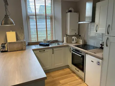a kitchen with a sink and a stove top oven at 34 James St cosy 2 bedroom, ground floor apartment, garden in Helensburgh