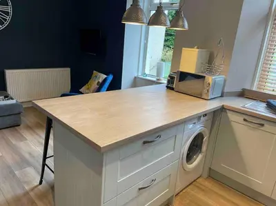 a kitchen with a counter top with a washing machine at 34 James St cosy 2 bedroom, ground floor apartment, garden in Helensburgh