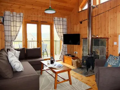 a living room with a couch and a fireplace at Loch Aweside Forest Cabins in Dalavich
