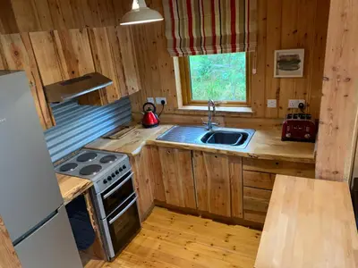 a kitchen with a sink and a stove at Loch Aweside Forest Cabins in Dalavich