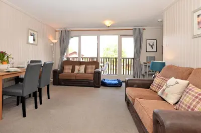 a living room with a couch and a table at Blairlagan Lodge in Hunters Quay