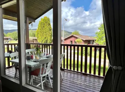 a balcony with a table and chairs on a deck at Blairlagan Lodge in Hunters Quay