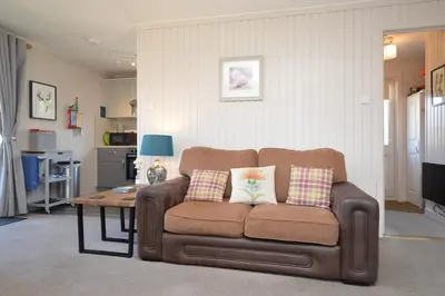 a living room with a couch and a table at Blairlagan Lodge in Hunters Quay