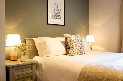 a bedroom with a bed and two lamps on a night stand at Stunning 2 bed flat with parking, and garden with mountain views in Crieff
