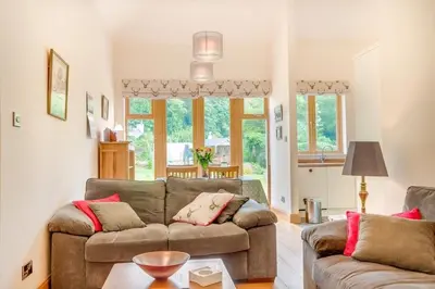 a living room with a couch and a table at Kinnen Cottage in Creetown