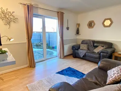 a living room with a couch and a window at Cosy 2 bedroom home with free parking near city in Edinburgh
