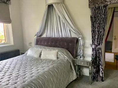a bedroom with a bed with a canopy at Pollokshields Burgh Hall Lodge Houses in Glasgow
