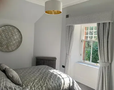 a bedroom with a bed and a window at Pollokshields Burgh Hall Lodge Houses in Glasgow