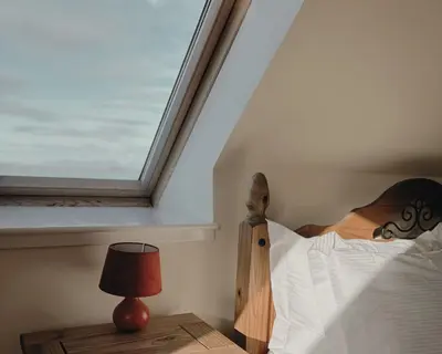 a bedroom with a bed and a window at Honeysuckle Cottage in Killean