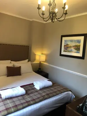 a bedroom with a bed and a chandelier at Stonefield Castle Hotel ‘A Bespoke Hotel’ in Stonefield