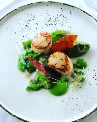 a plate of food with scallops and vegetables at Stonefield Castle Hotel ‘A Bespoke Hotel’ in Stonefield