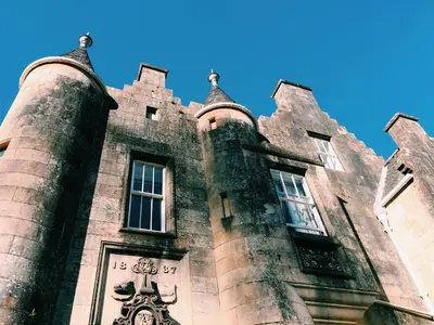 a building with a tower with a clock on it at Stonefield Castle Hotel ‘A Bespoke Hotel’ in Stonefield
