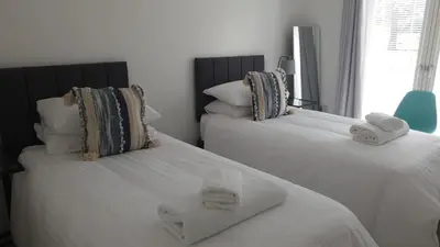 two beds in a bedroom with towels on them at Mhuilinn Apartment in Stirling