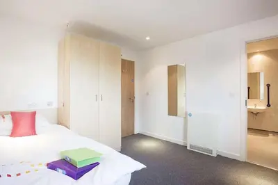 a bedroom with a bed with a book on it at Edinburgh College Residence in Edinburgh