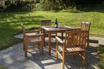 a wooden table with two chairs and a bottle of wine at Skerrow in New Galloway