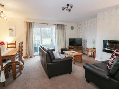 a living room with a couch and a tv and a table at Barley Cottage in Newton Stewart