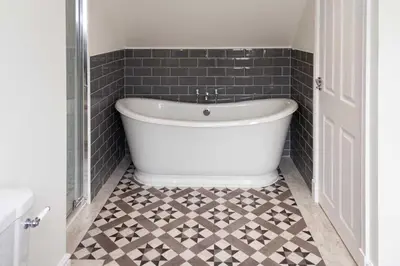 a bath tub in a bathroom with a tiled floor at Stroan in New Galloway