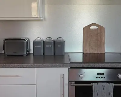 a kitchen with a counter top with a wooden box at Blaeberry Cottage in Killean