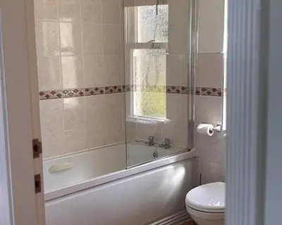 a bathroom with a tub and a toilet and a window at Primrose Cottage in Killean