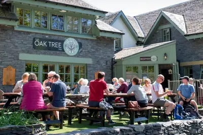a group of people sitting at tables outside of a restaurant at Oak Tree Inn in Balmaha