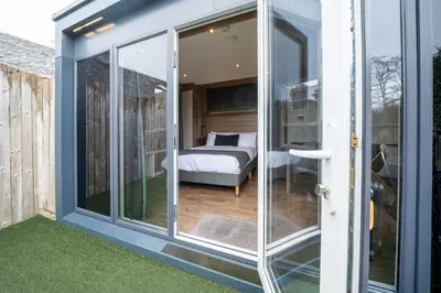 a room with sliding glass doors leading to a bedroom at Oak Tree Inn in Balmaha