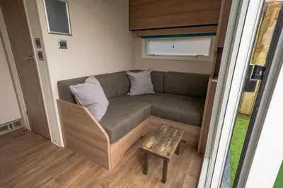 a couch in a tiny house with a table at Oak Tree Inn in Balmaha