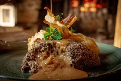 a piece of food with sauce on a green plate at Oak Tree Inn in Balmaha