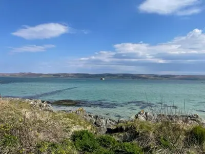 a view of the ocean with a boat in the distance at Harebell Cottage in Killean