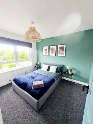 a blue bedroom with a bed and a window at Spacious 5bed house, FREE parking, NO PARTY ! in Glasgow