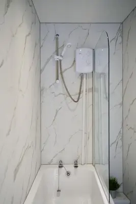 a bath tub with a shower in a bathroom at 1 BDR Apt By Caledonia Luxe Stays Short Lets & Serviced Accommodation Lanark in Douglas