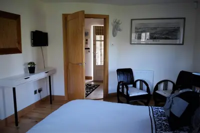 a bedroom with a bed and a desk and chairs at Loch Lomond Unique Selfcontained bed+bathroom in Alexandria