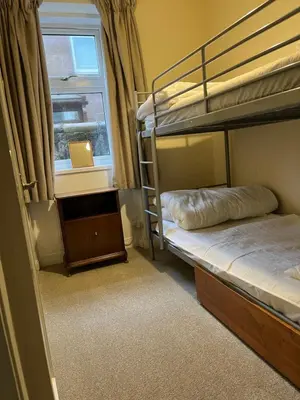 a bedroom with two bunk beds and a window at 4 Kames Bay in Millport