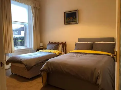 a bedroom with two beds next to a window at 4 Kames Bay in Millport