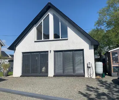 a house with two garage doors on a driveway at Newton Bothy in Stirling