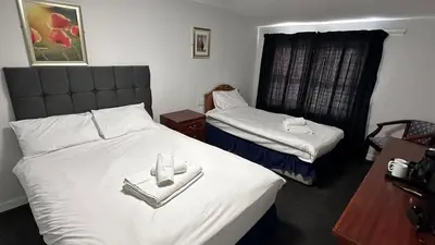 a hotel room with two beds with towels on them at The Bruce Hotel in Newton Stewart