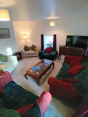 a living room with couches and a flat screen tv at Killean Farmhouse Cottages in Auchnangoul