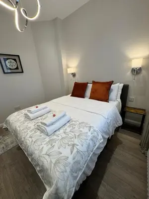 a bedroom with a large bed with towels on it at Luxury 2 Bedroom Cottage in West Calder
