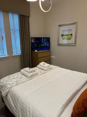 a bedroom with a bed with two towels on it at Luxury 2 Bedroom Cottage in West Calder