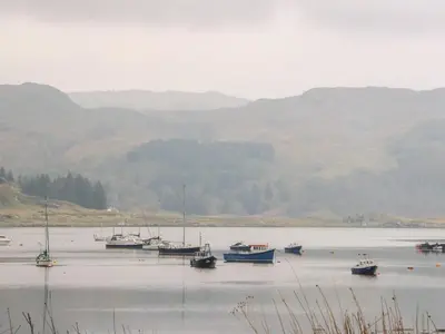 a group of boats sitting in a large body of water at Balvicar Beag in Oban